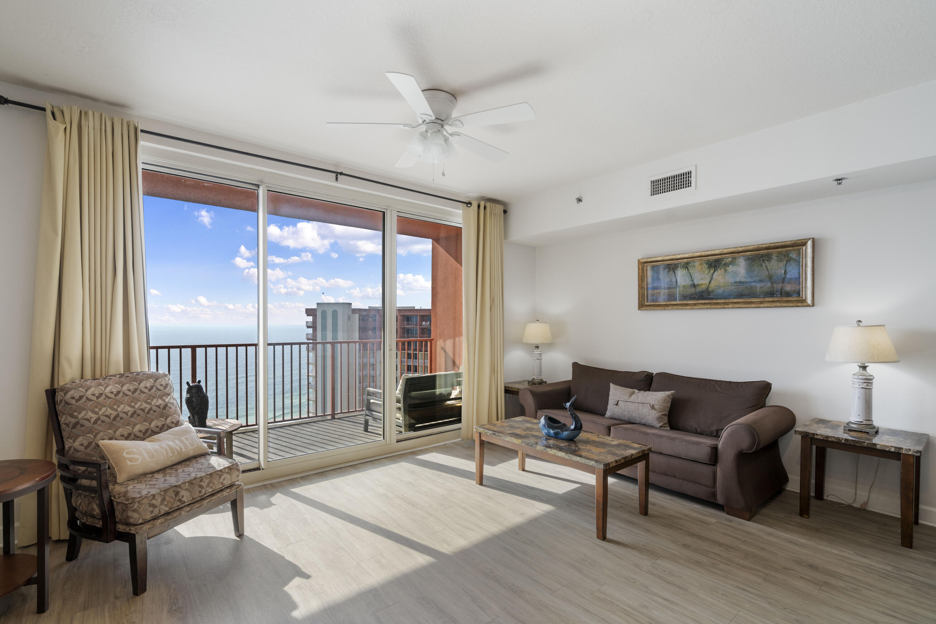 Condo living room with sliding balcony doors overlooking the ocean.