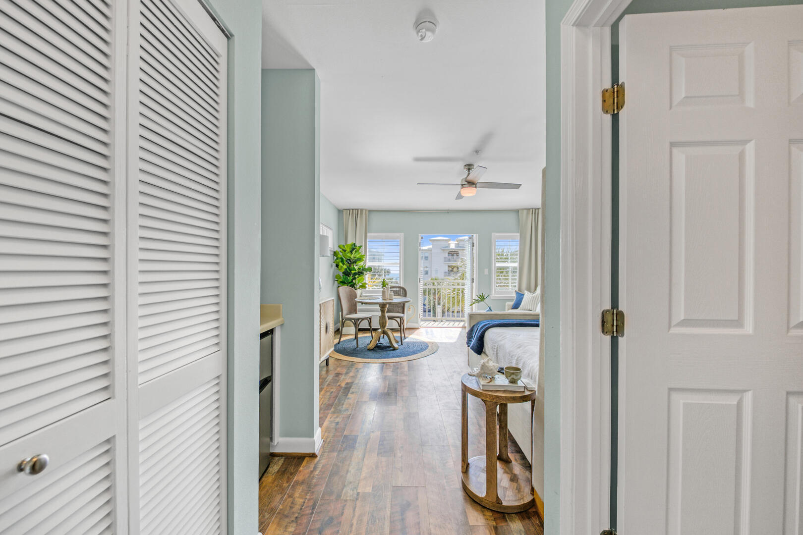 Furnished studio condo with a bed, dining table, and balcony doors