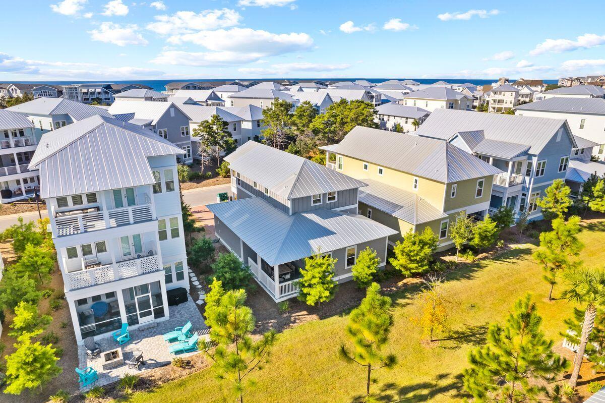 Aerial view of coastal homes with metal roofs and the Gulf on the horizon.