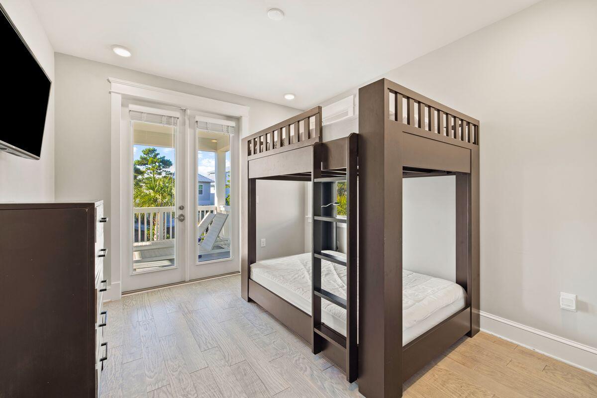 Bedroom with a dark wood bunk bed beside glass doors opening onto a porch.