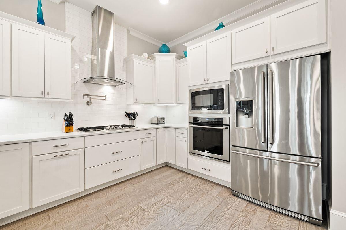 Bright white kitchen with stainless steel appliances and a gas cooktop.