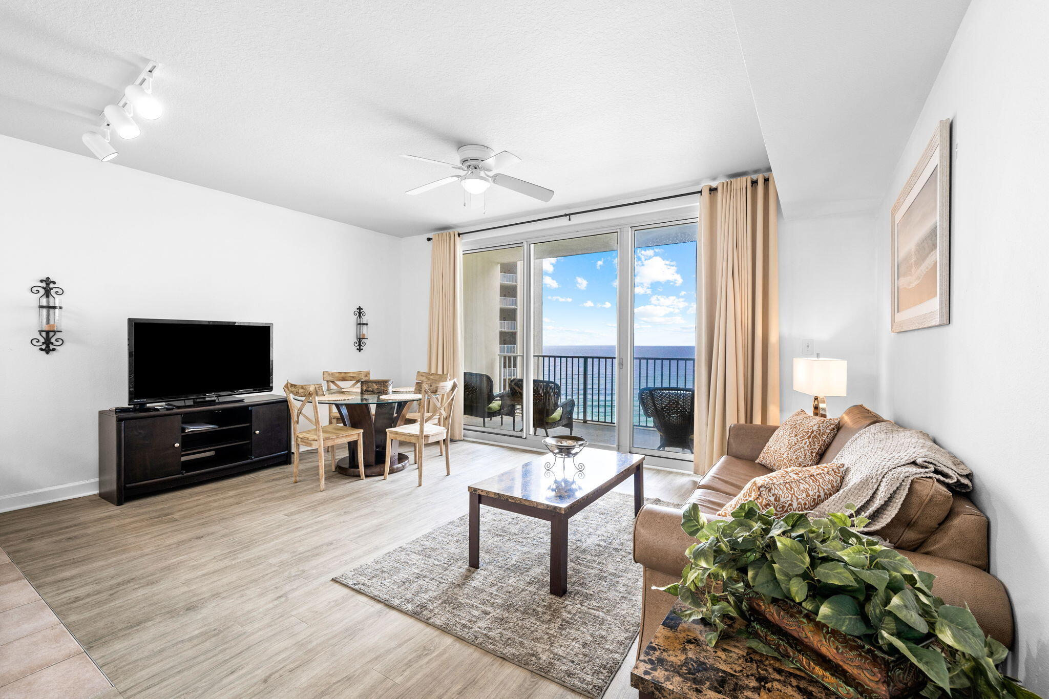 Furnished condo living room with sliding glass doors overlooking the ocean.