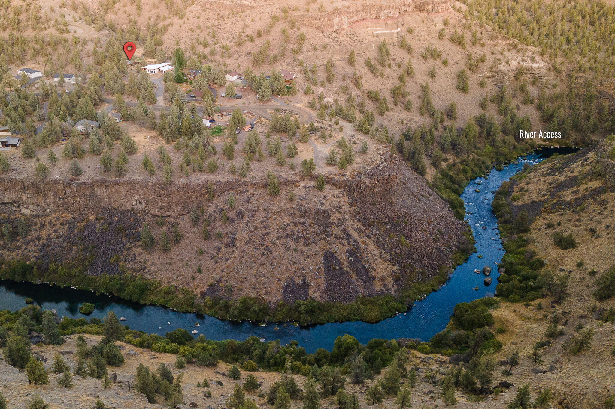 Aerial view of homes on a rocky plateau above a winding river.