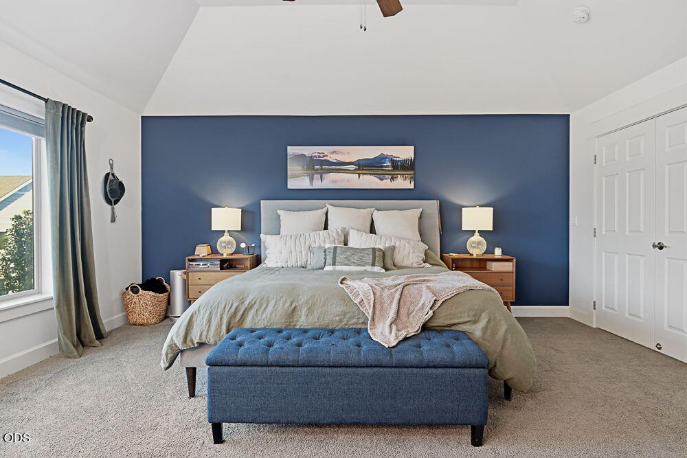 Staged bedroom with a king-size bed, navy accent wall, and blue upholstered bench.