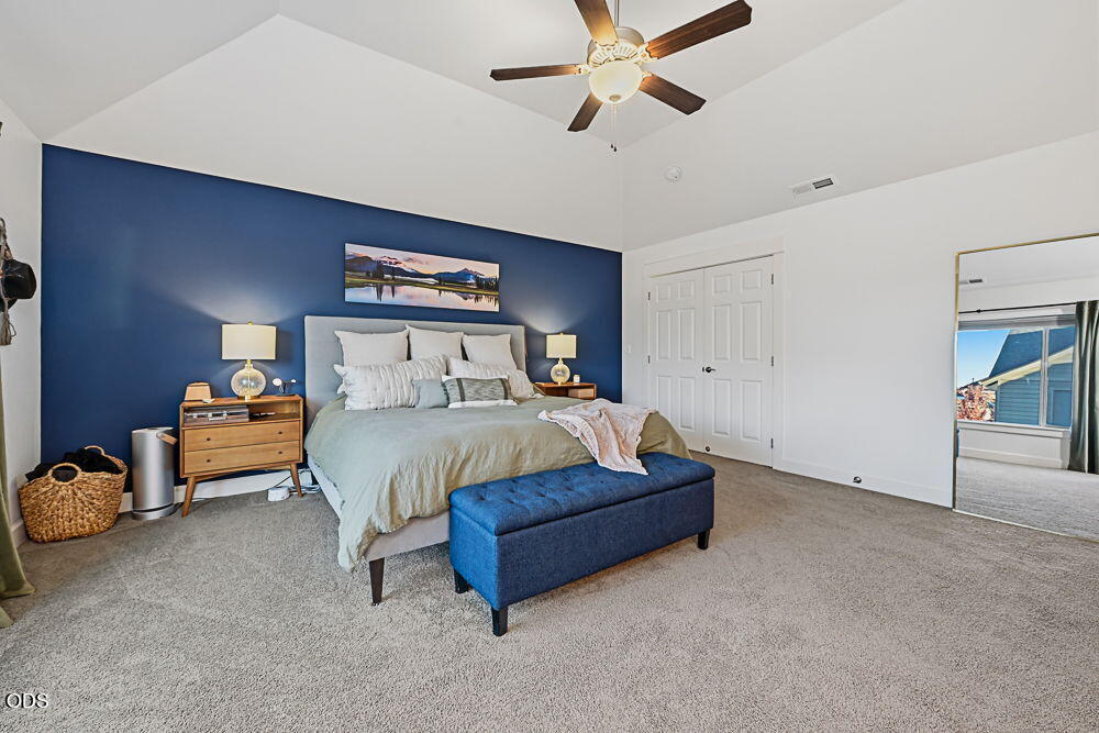 Furnished bedroom with a navy accent wall, king bed, and blue upholstered bench.