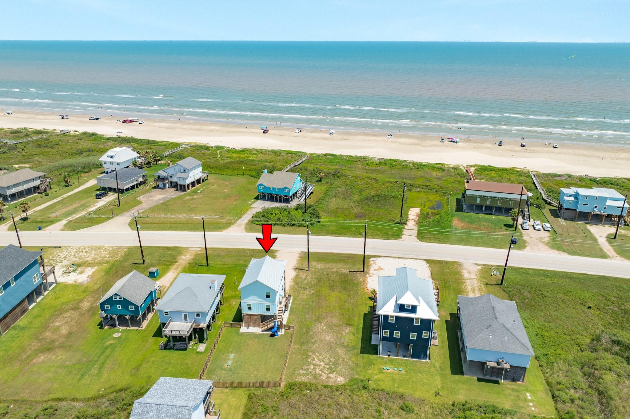 Aerial view of the arrow-marked coastal property across the road from the beach.