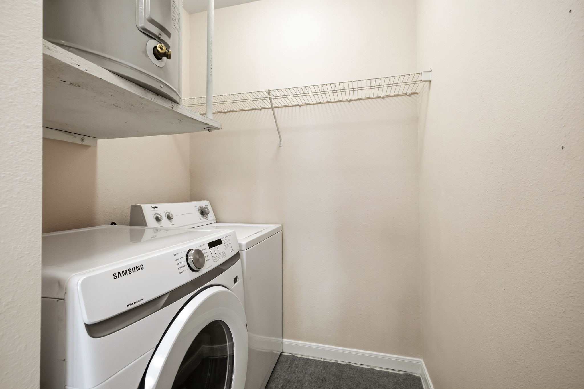 Laundry room with a Samsung front-loading washer, top-loading dryer, and wire shelving.
