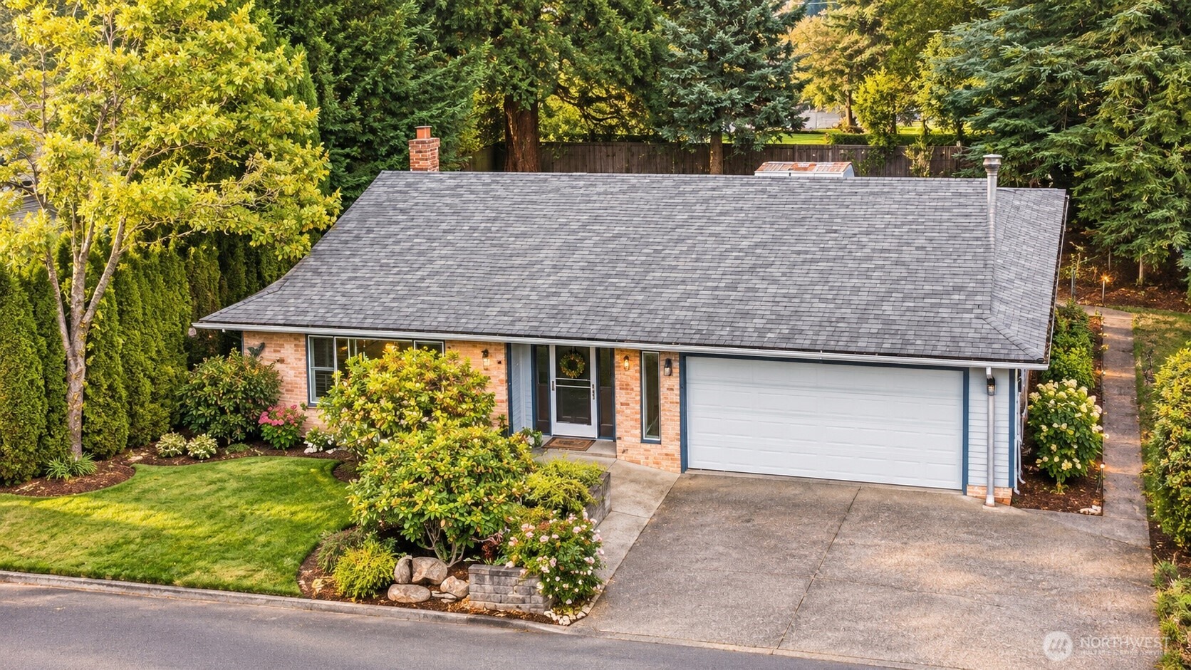 Single-story home with brick facade, attached two-car garage, and landscaped front yard.