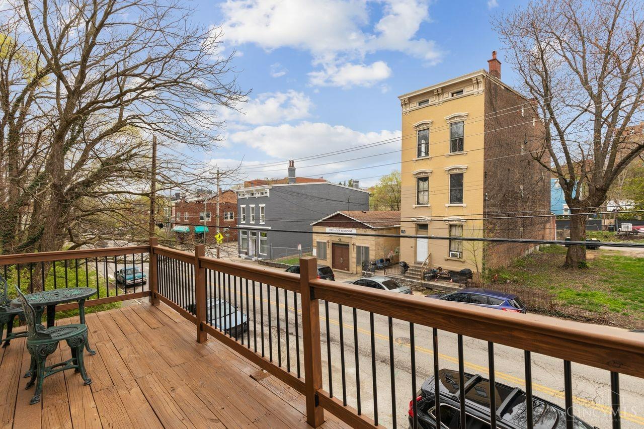 Wooden deck overlooks a street and neighboring brick buildings.