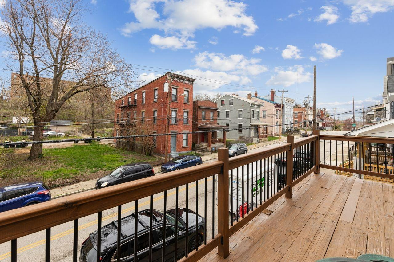 Raised wooden deck overlooking a Cincinnati street lined with brick and painted buildings.