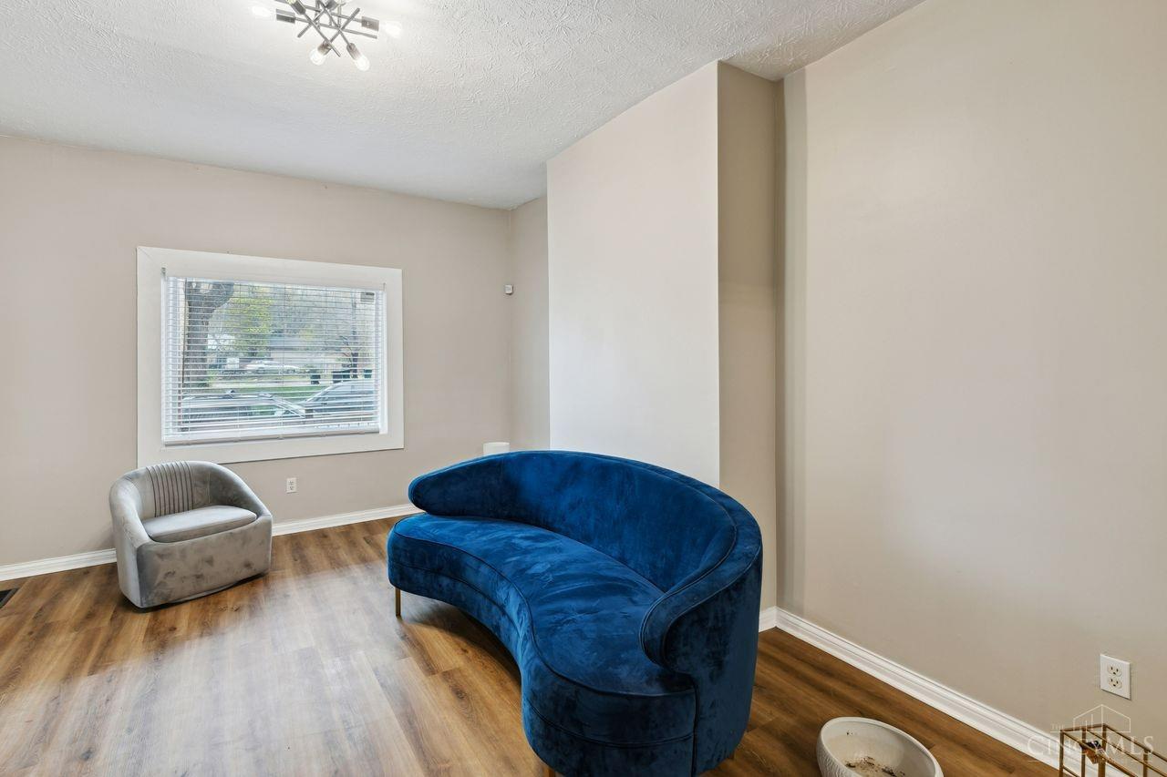 Living room with a curved blue sofa, gray chair, and wood flooring.