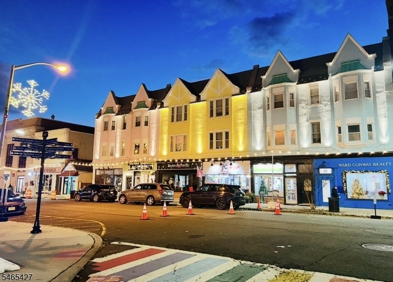 Illuminated gabled storefronts along a Westfield street at night, including the Ward Conway Realty office.