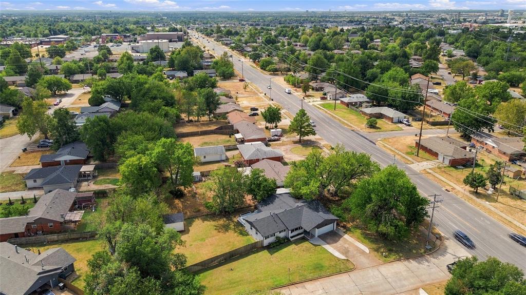 Aerial view of a corner-lot home beside South Boulevard, with mature trees and neighboring houses.