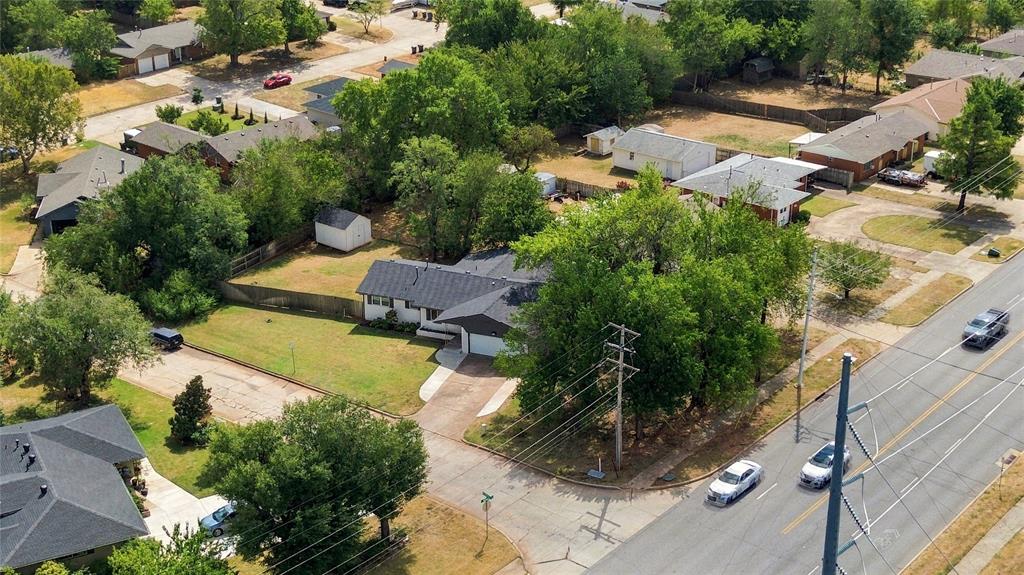 Single-story home on a corner lot with a fenced yard and mature trees.
