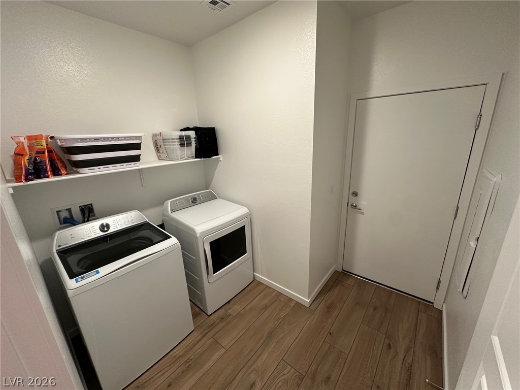 Laundry room with a top-loading washer, front-loading dryer, and wall shelf.