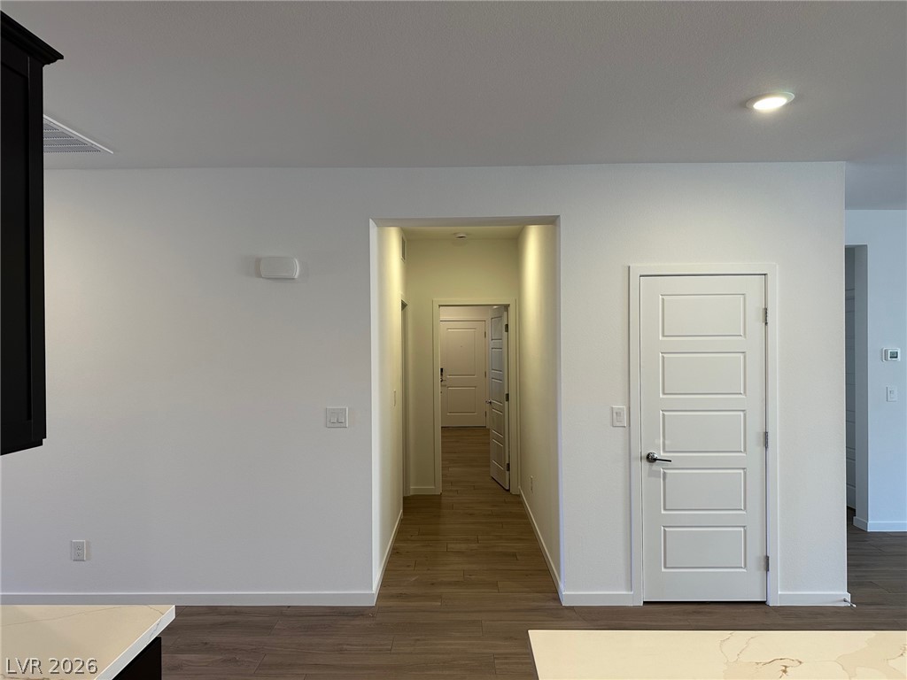 Interior hallway with wood-look flooring and white paneled doors.