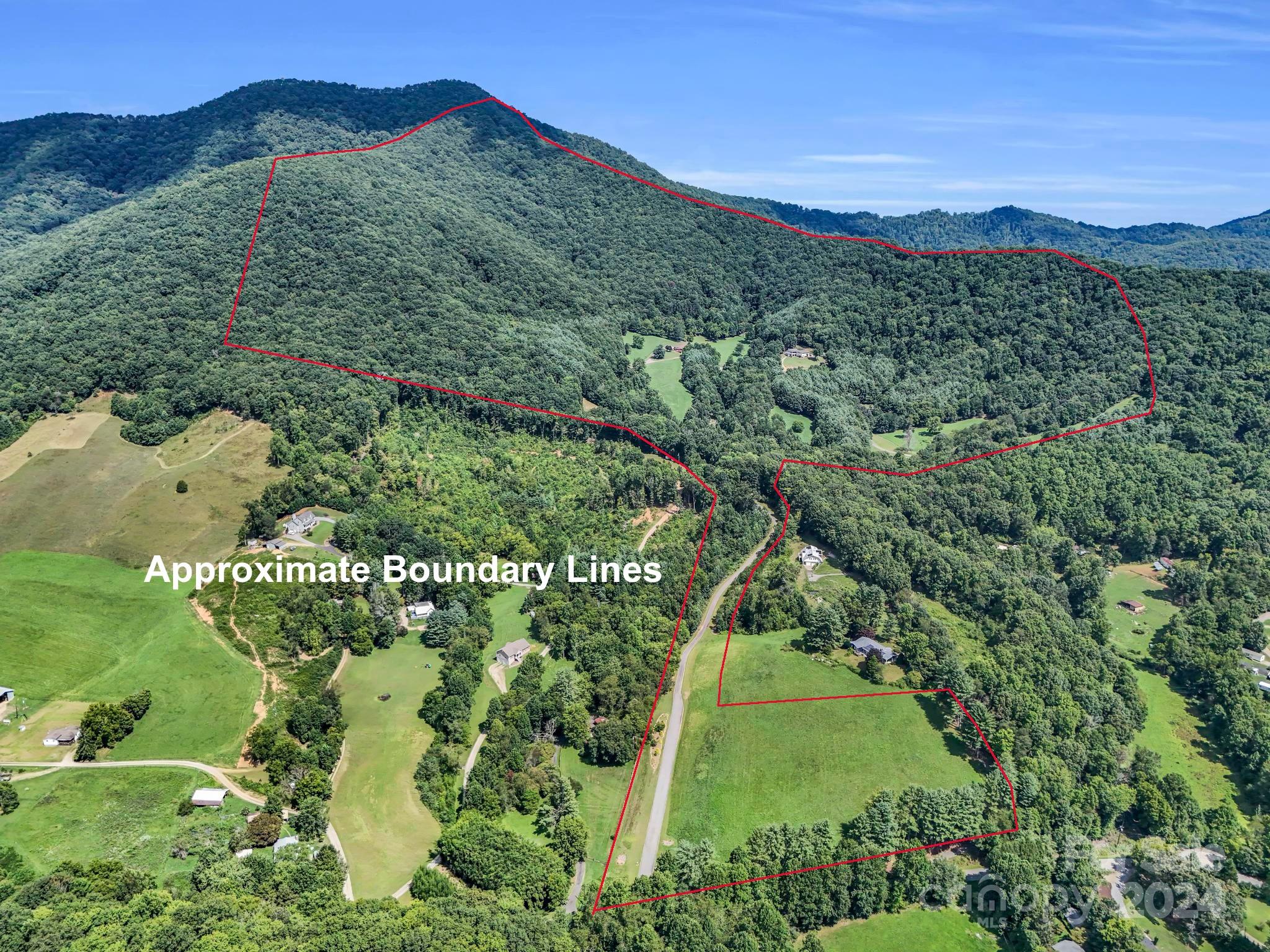 Aerial view of wooded Candler hills and scattered homes outlined by red approximate boundary lines.