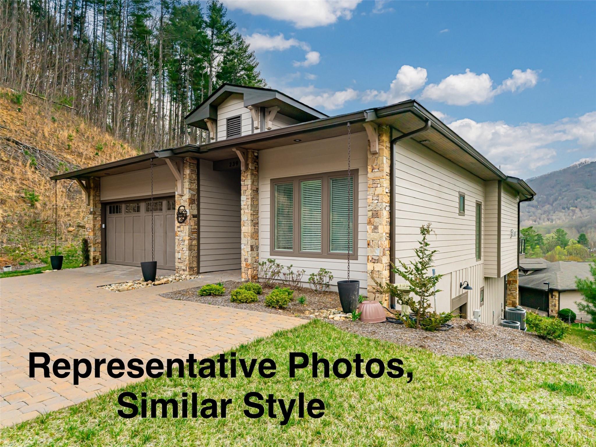Modern home with stone accents and attached garage on a wooded mountain slope.