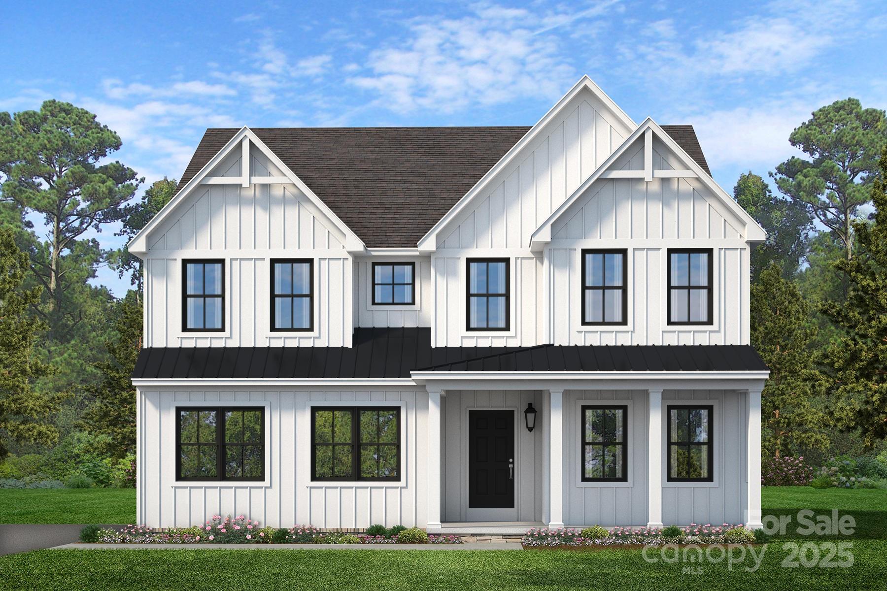 White two-story house with black-framed windows, several front gables, and a dark metal porch roof.