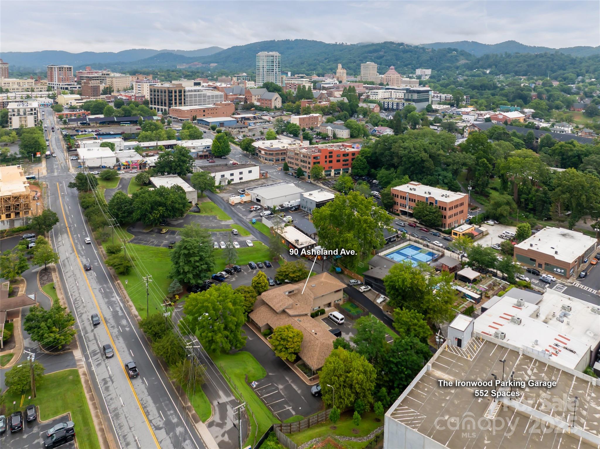 Aerial view of downtown Asheville, with the Blue Ridge mountains behind the city and labeled Asheland Avenue property.