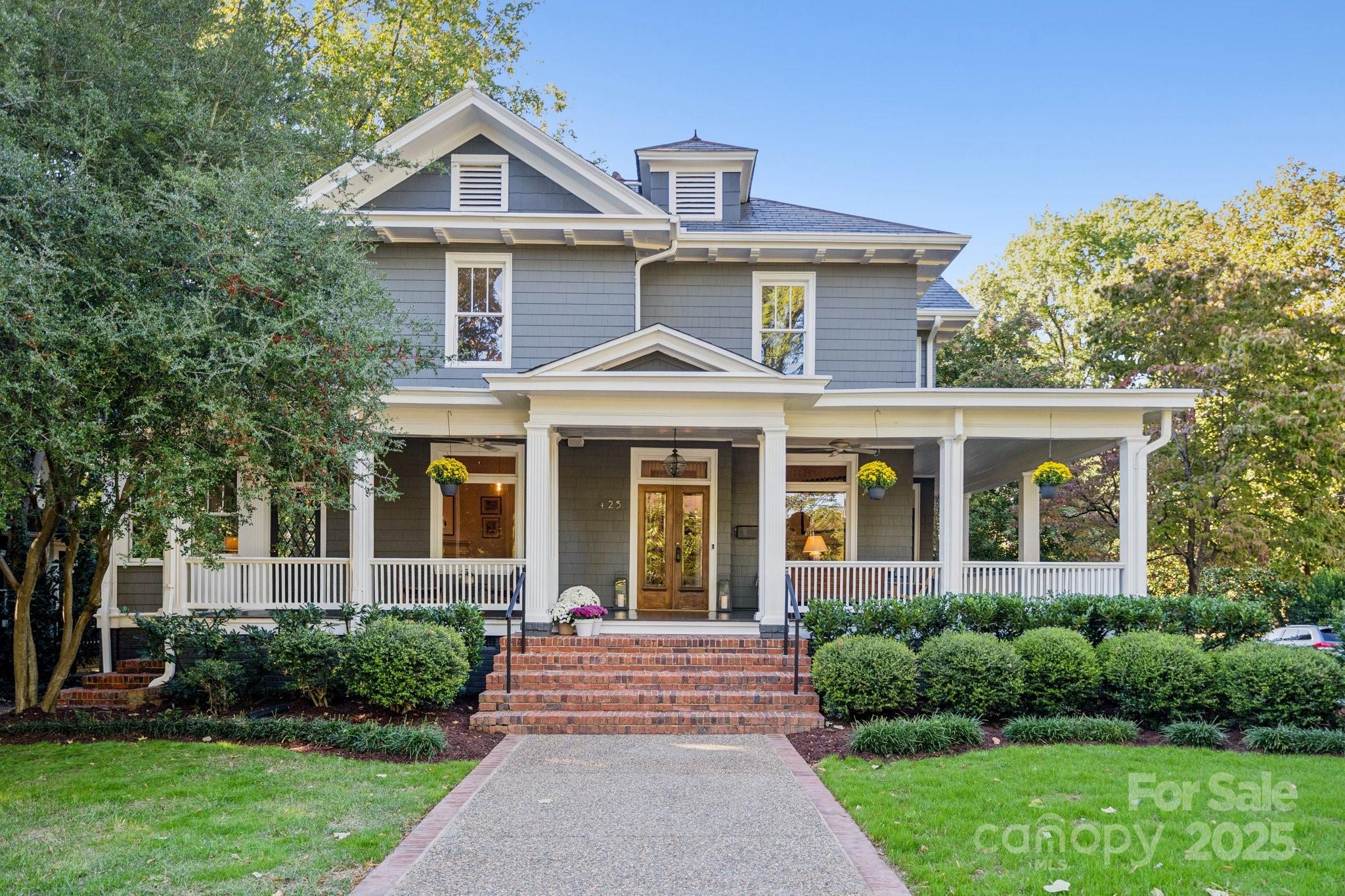 Gray two-story house with a wide covered porch, white columns, and brick front steps.