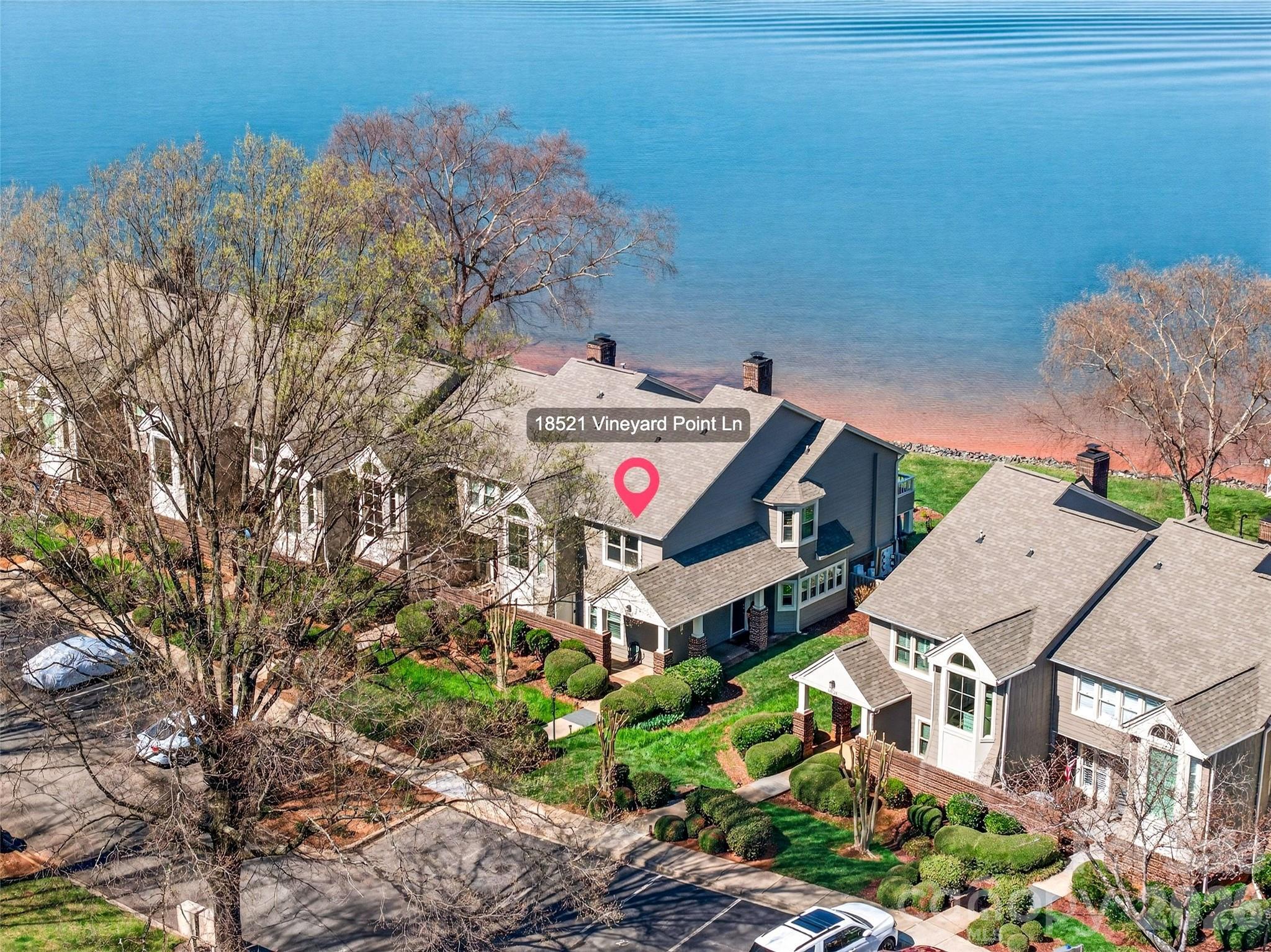 Lakefront condo buildings with landscaped grounds, viewed from above.