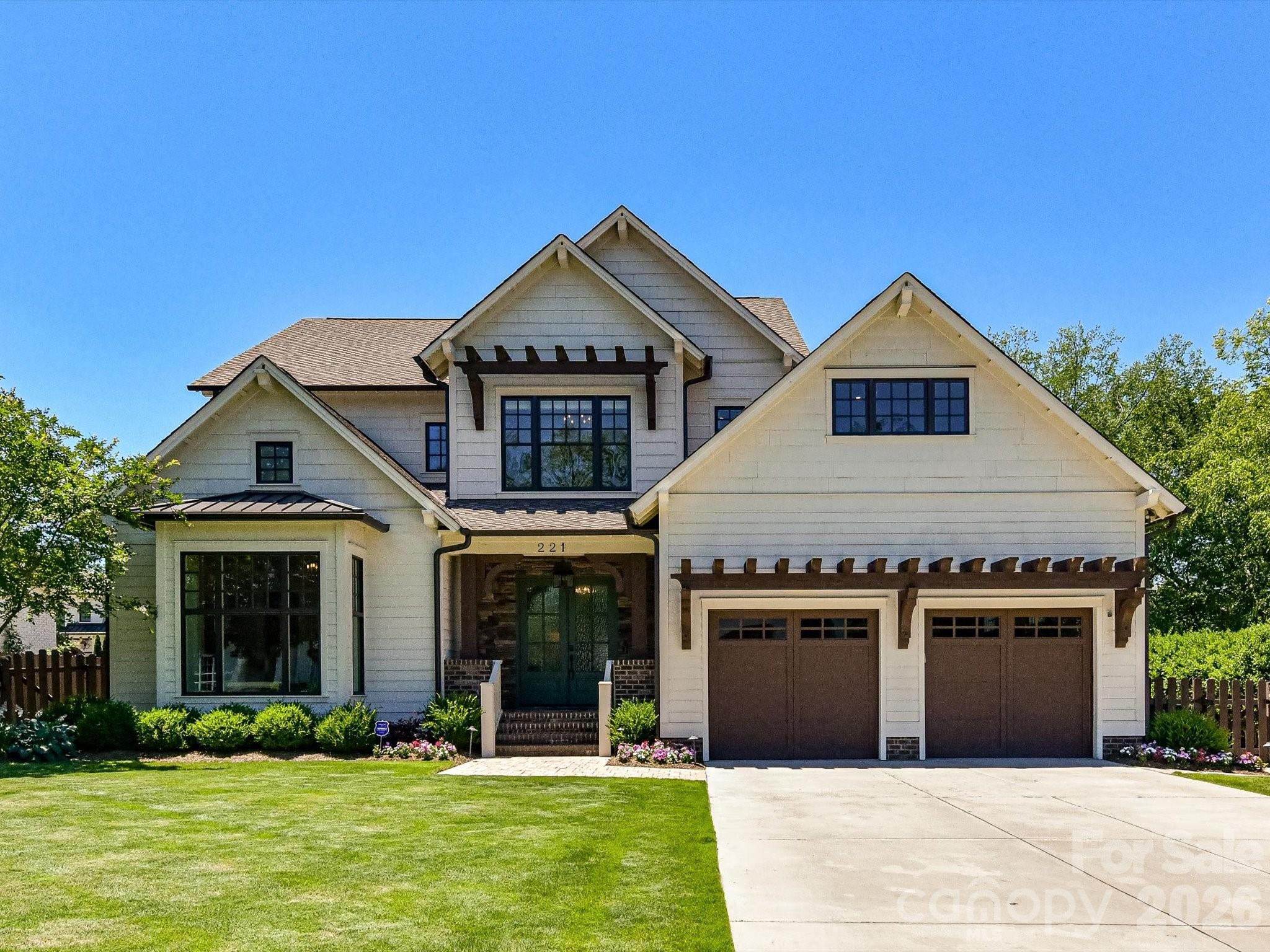 White two-story home with multiple gables, a covered entry, and a two-car garage.