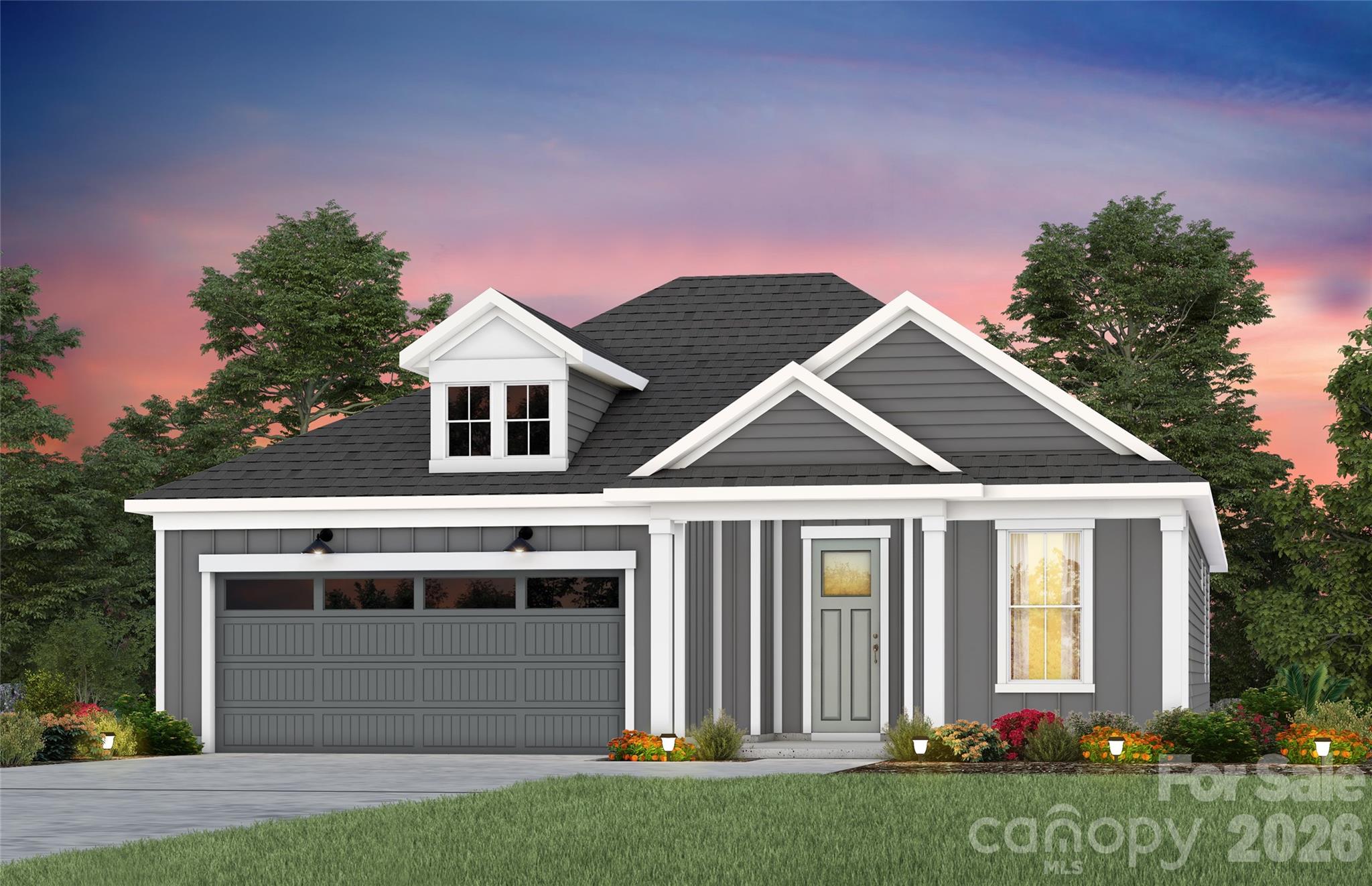 Gray single-story home with white trim, a double garage, and landscaped flower beds at dusk.