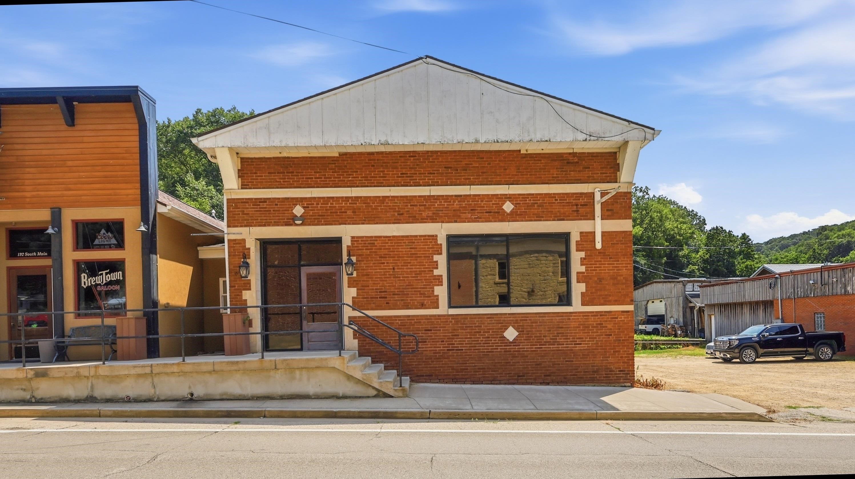 Red-brick downtown building beside BrewTown Saloon, with a pickup truck parked nearby.