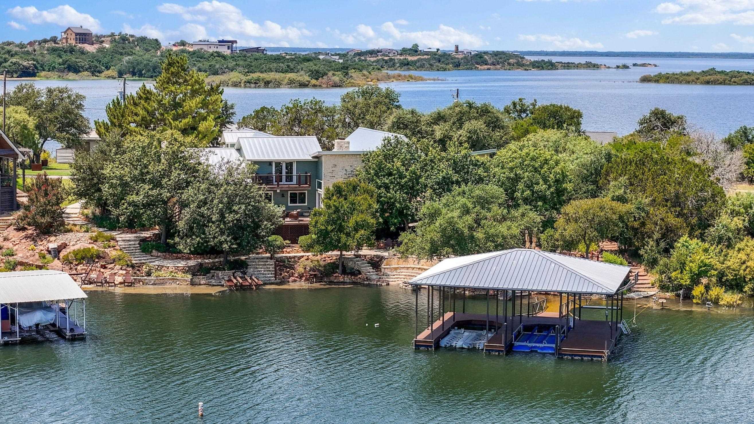 Waterfront homes and covered boat docks along a wooded shoreline, with the lake stretching into the distance.