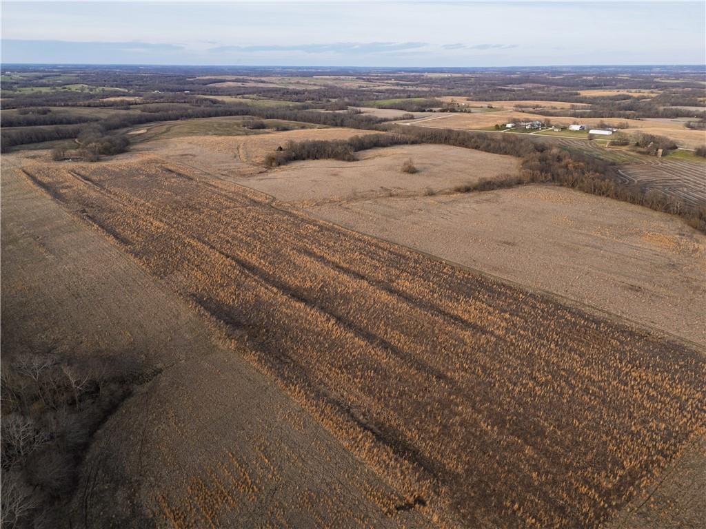 Aerial view of Ray County farmland with broad brown fields, wooded edges, and distant farm buildings.
