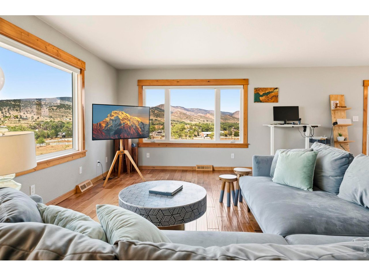 Living room with gray sofas and large windows overlooking a mountain landscape.
