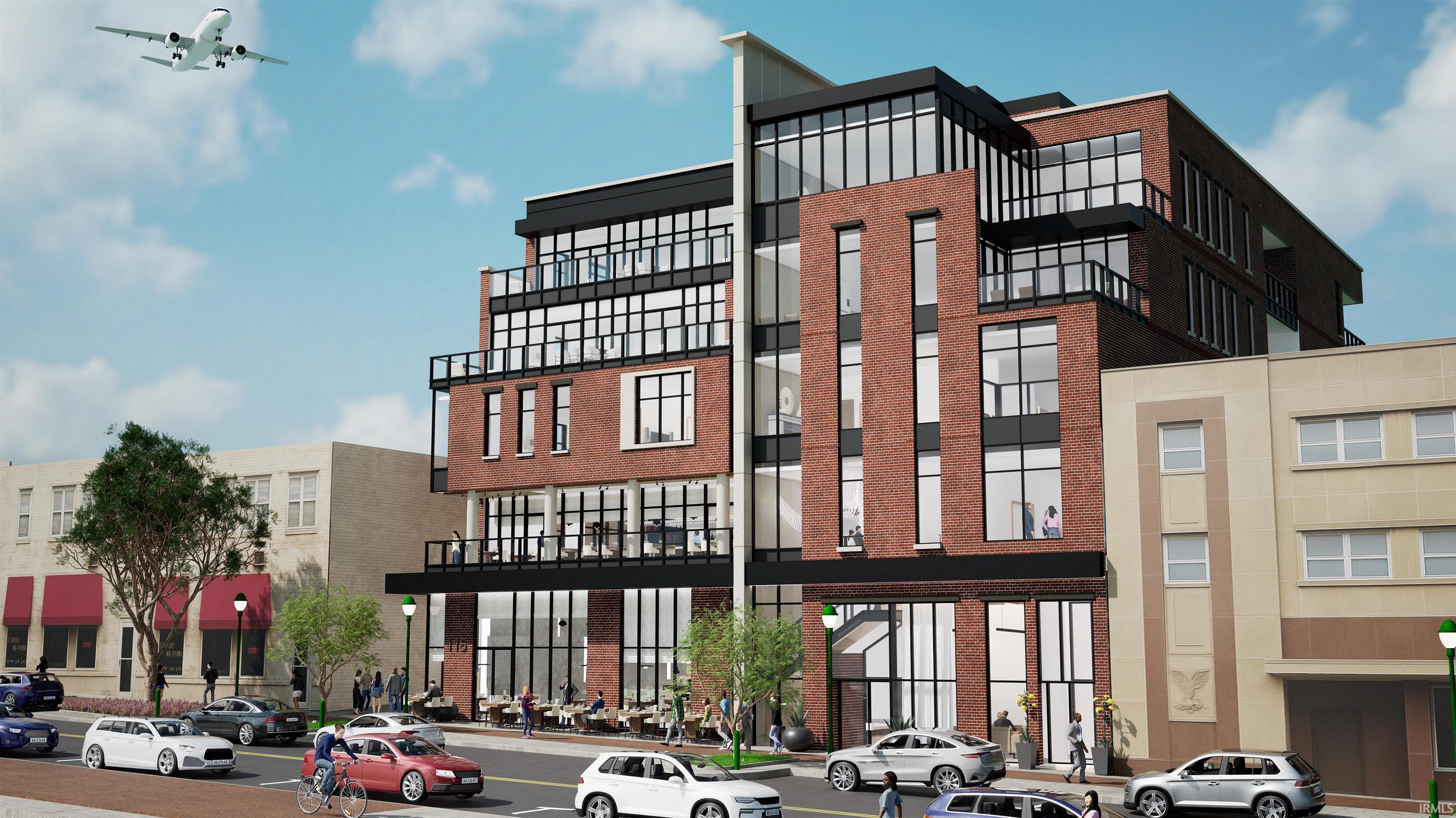 Modern brick and glass multi-story building on a busy street with storefronts and pedestrians.