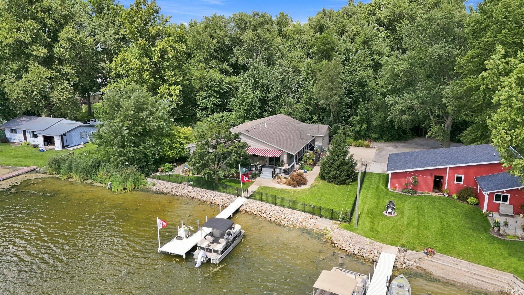 Waterfront homes with private docks and boats along a wooded shoreline.
