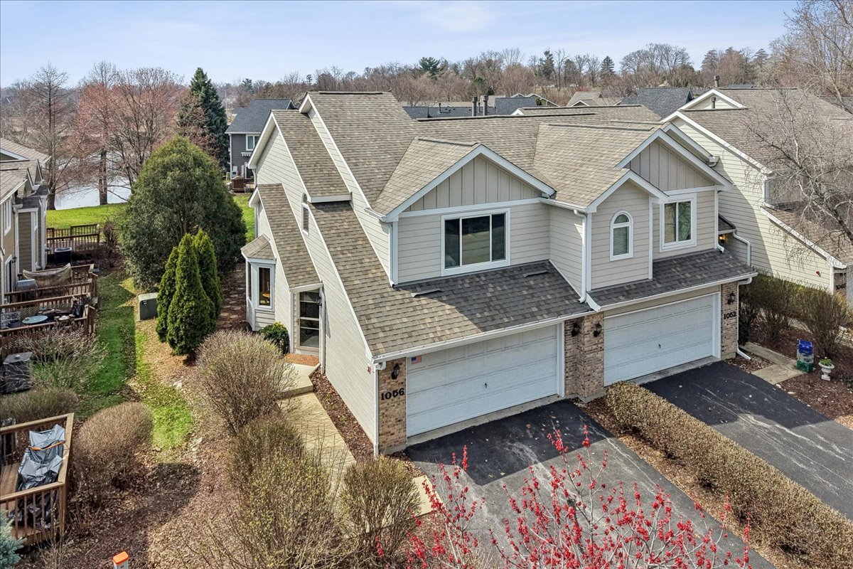 Adjoining gray homes with gabled roofs and double garages, seen from above.