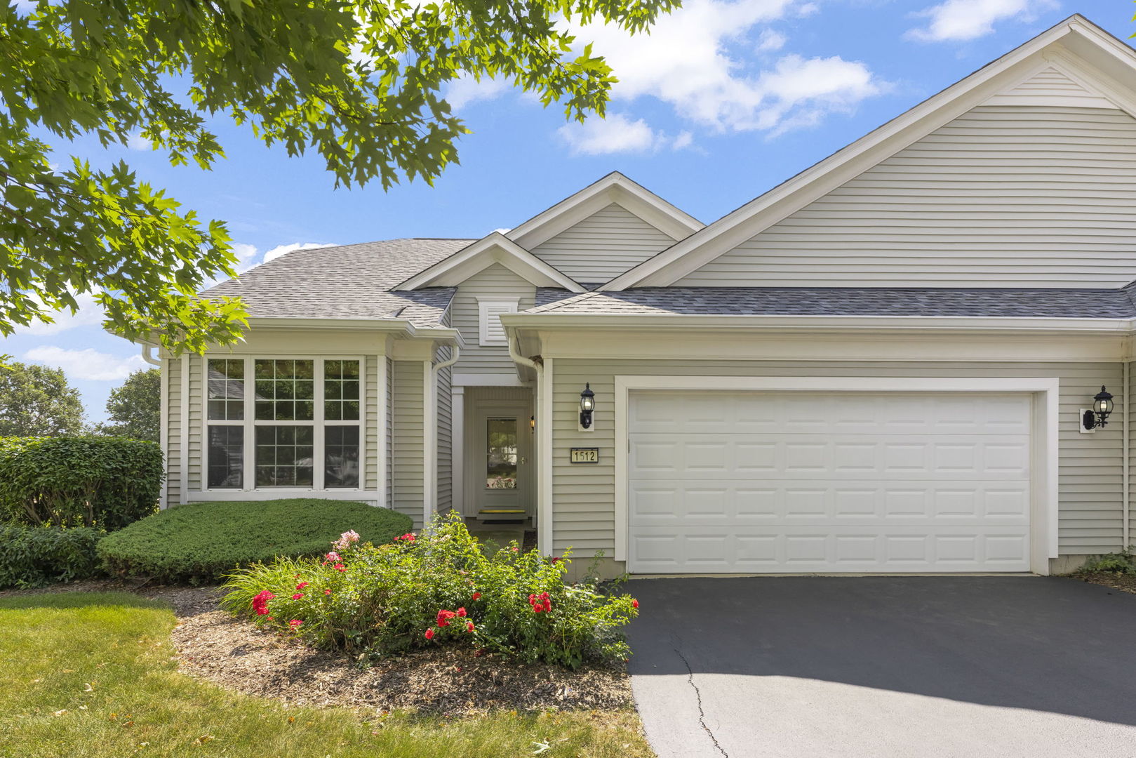 Home exterior with a large attached garage, landscaped flower beds, and house number 1512.