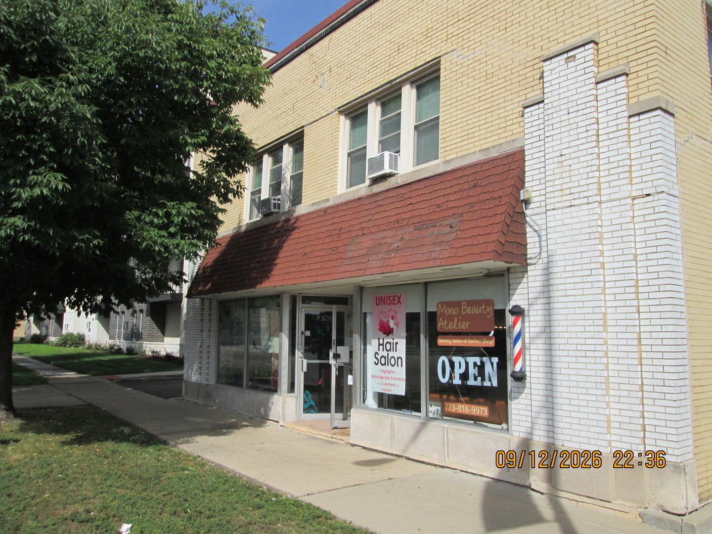 Yellow-brick Norridge storefront with a red-tiled awning and salon signs in the windows.