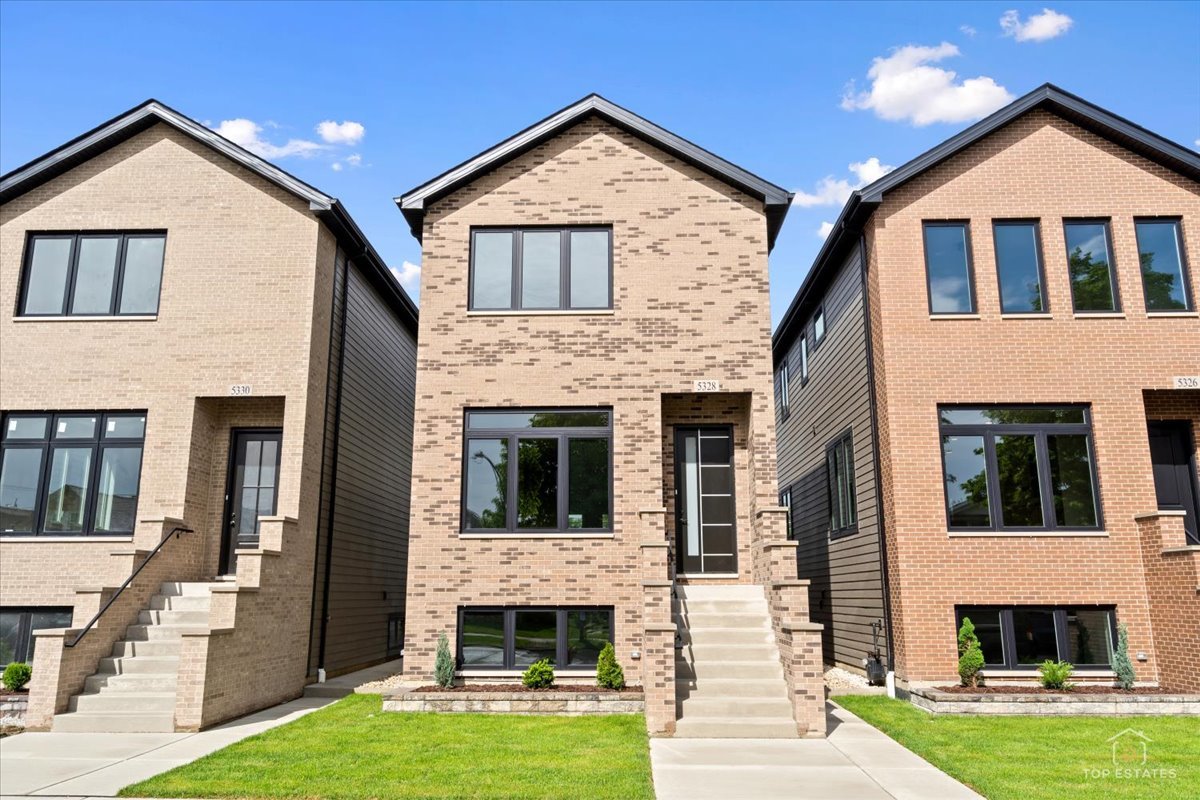 Three adjoining brick townhouses with contrasting facades, dark-framed windows, front steps, and small lawns.
