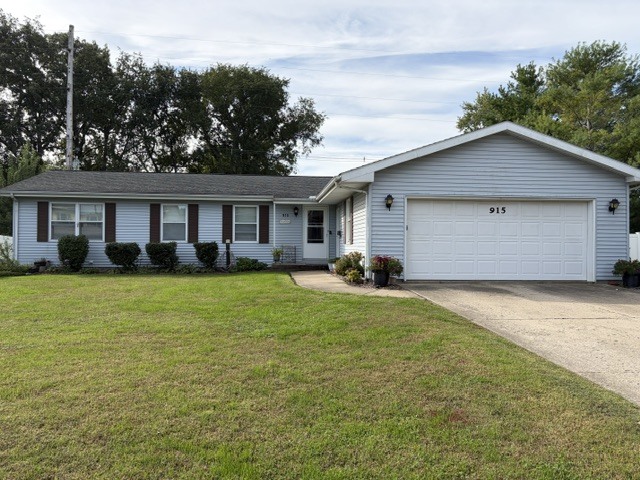 Light-blue single-story house with dark shutters, a white two-car garage, and a broad green lawn.