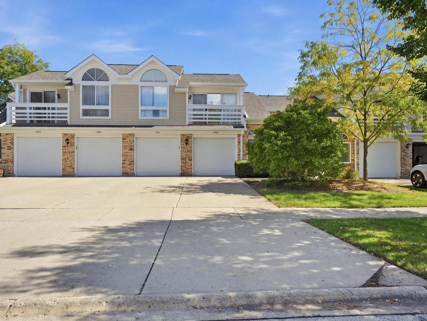 Attached townhomes with brick garage fronts, second-floor balconies, and distinctive arched windows.