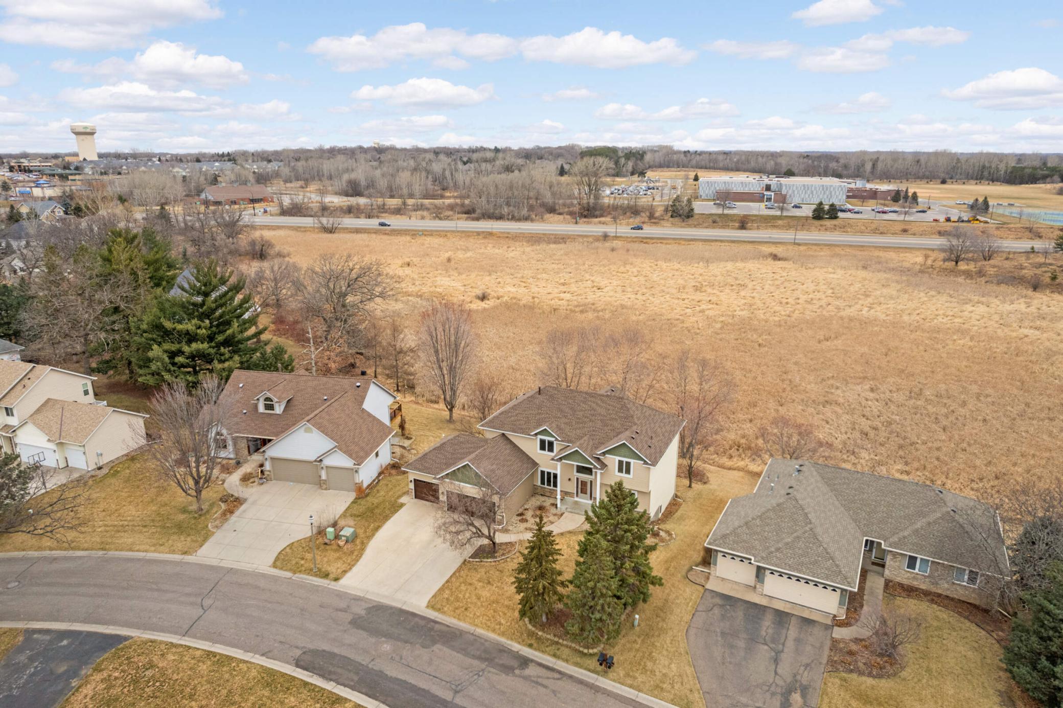 Oakdale homes beside a broad open field, with a water tower in the distance.