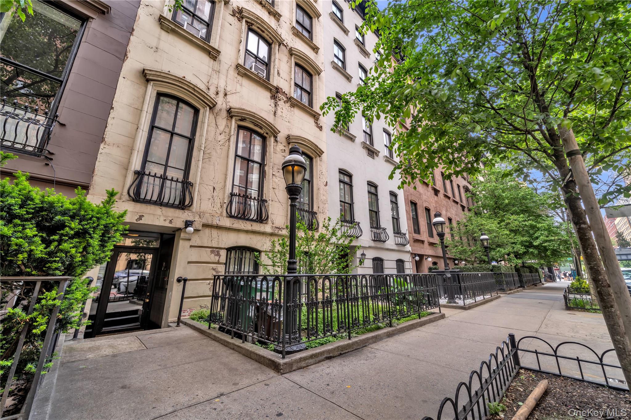 Chelsea apartment buildings with ornate facades and iron railings along a tree-lined sidewalk.