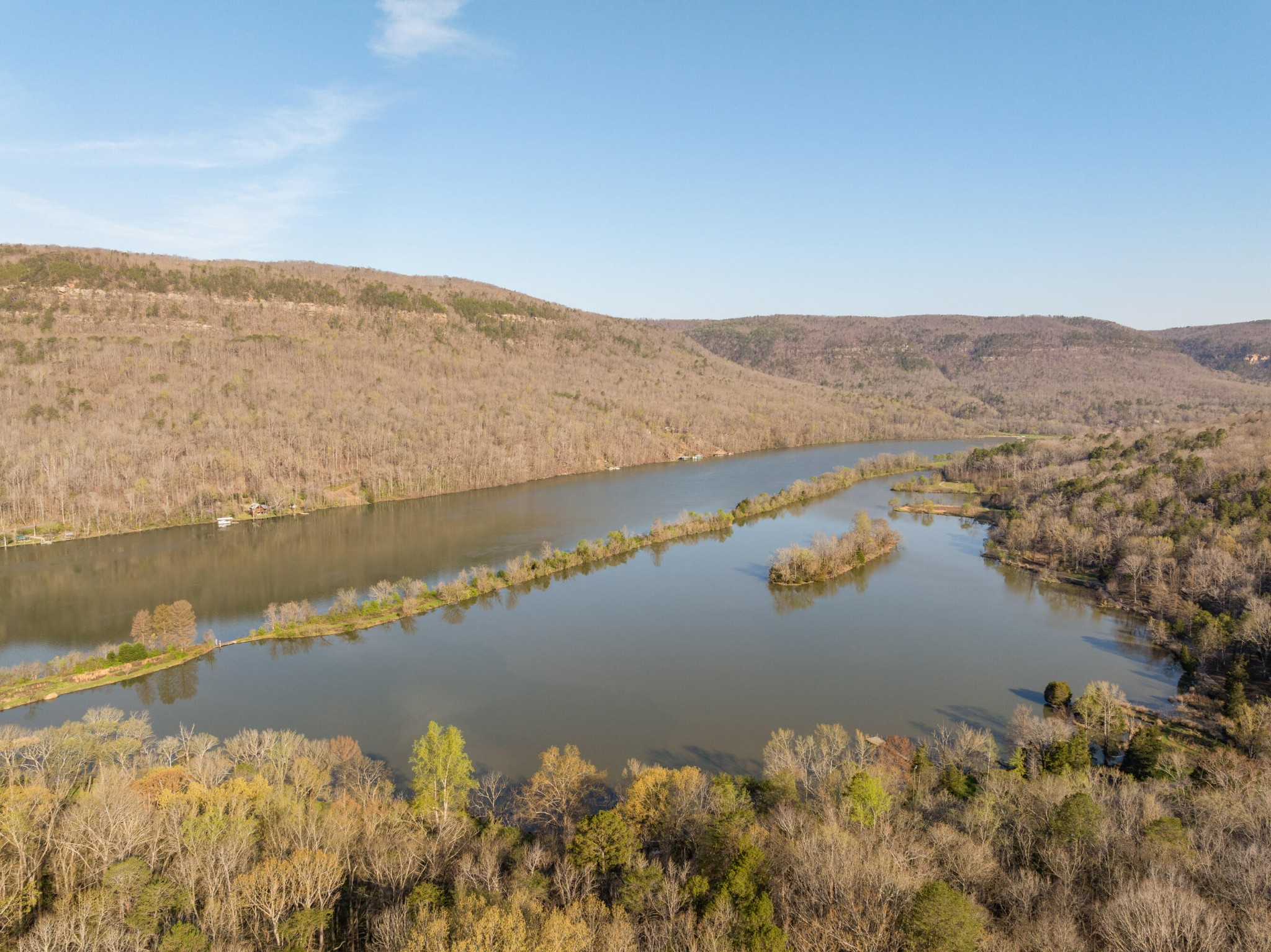 Winding river through wooded hills, seen from above in autumn.
