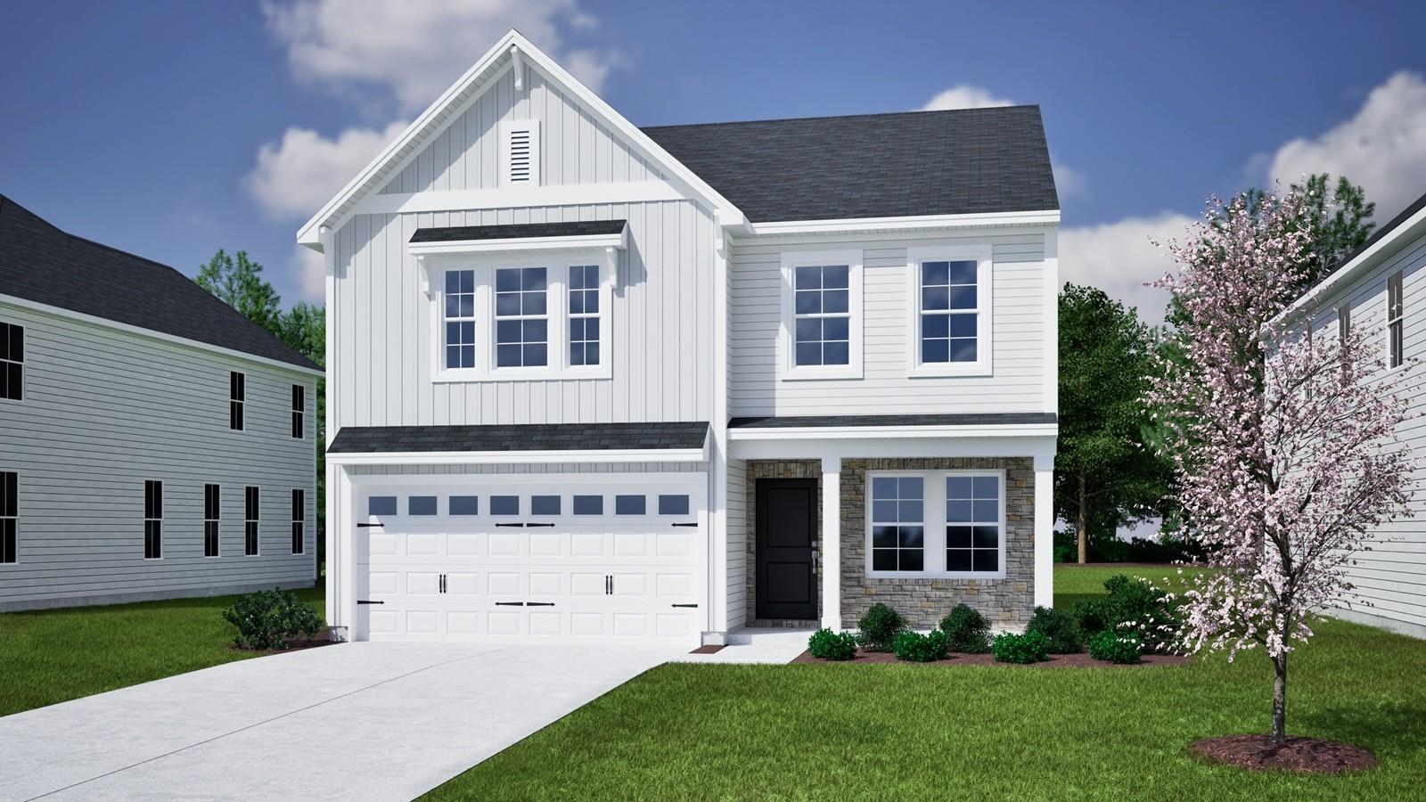 Two-story white house with a double garage, stone entry accents, and a flowering tree in the lawn.