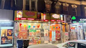 Nighttime storefronts with colorful signs and an illuminated OPEN sign.